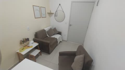 Sofá, quadros e mesinha infantil, perto da entrada